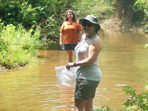 Teachers Marilyn Kinney (foreground) and Candace Bridges collect water samples in Flat Shoals Creek. Photo: Michelle Riley